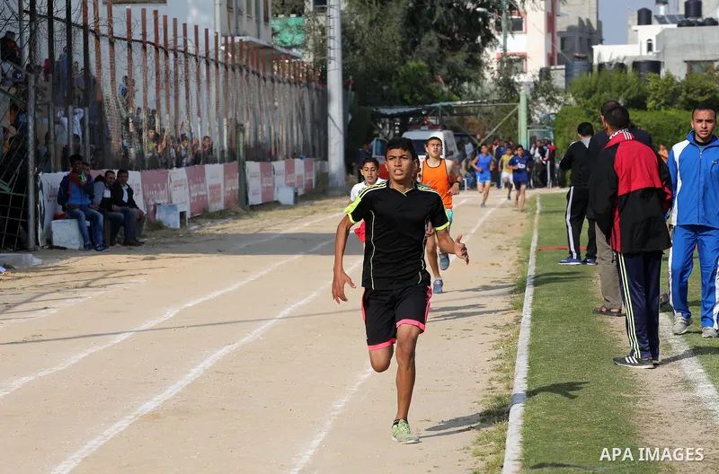 Palestinian youths take part in a local running championship at Yarmouk Stadium in Gaza city on March 21, 2016. Photo by Mohammed Asad