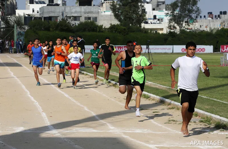 Palestinian youths take part in a local running championship at Yarmouk Stadium in Gaza city on March 21, 2016. Photo by Mohammed Asad