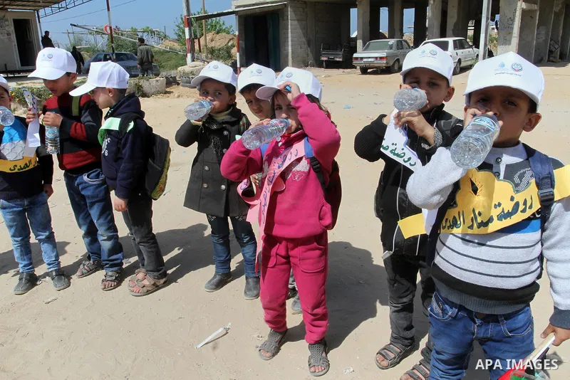 Palestinian childers drink water during a protest to demand the Egyptian goverment stopping pump large amounts of sea water along the border between Egypt and Gaza, southern Gaza Strip on March 22, 2016. Photo by Abed Ra...