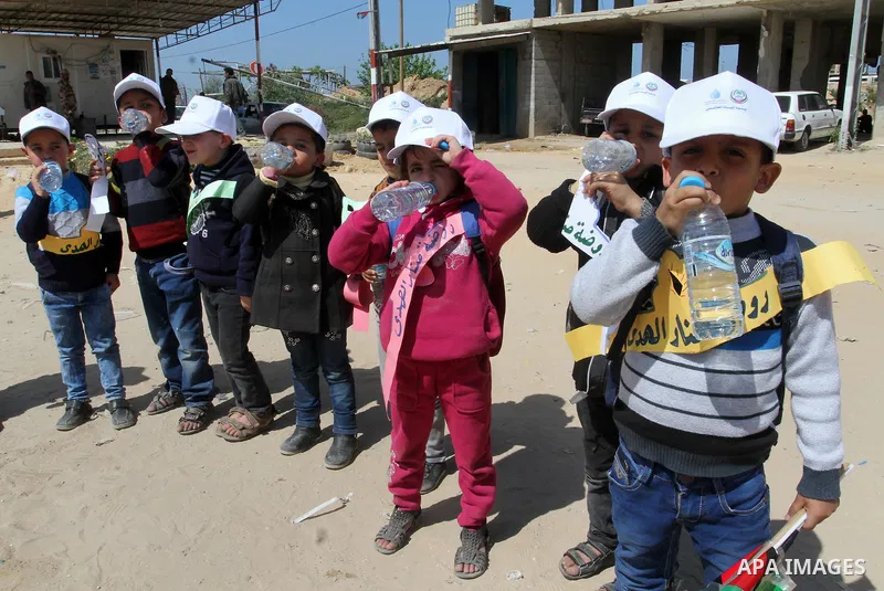 Palestinian childers drink water during a protest to demand the Egyptian goverment stopping pump large amounts of sea water along the border between Egypt and Gaza, southern Gaza Strip on March 22, 2016. Photo by Abed Ra...