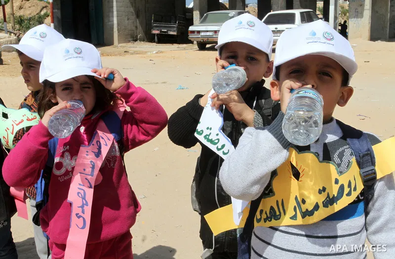 Palestinian childers drink water during a protest to demand the Egyptian goverment stopping pump large amounts of sea water along the border between Egypt and Gaza, southern Gaza Strip on March 22, 2016. Photo by Abed Ra...