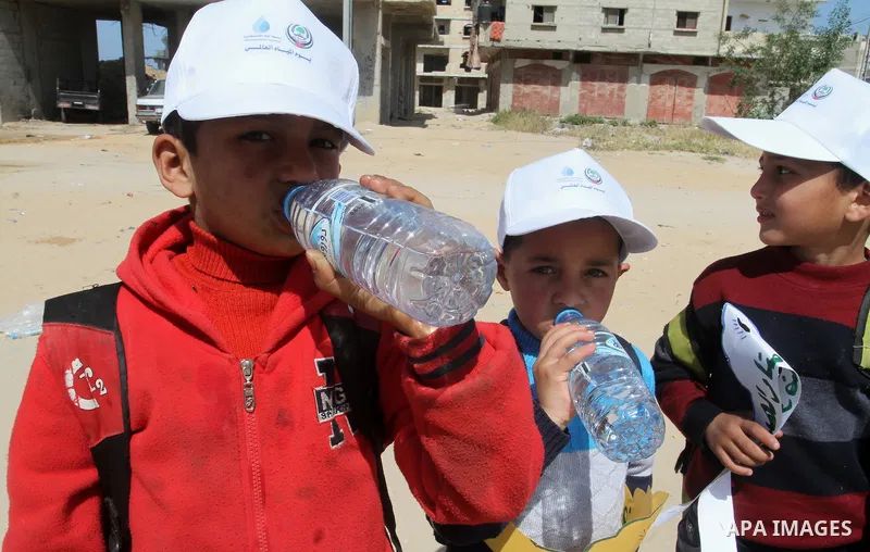 Palestinian childers drink water during a protest to demand the Egyptian goverment stopping pump large amounts of sea water along the border between Egypt and Gaza, southern Gaza Strip on March 22, 2016. Photo by Abed Ra...