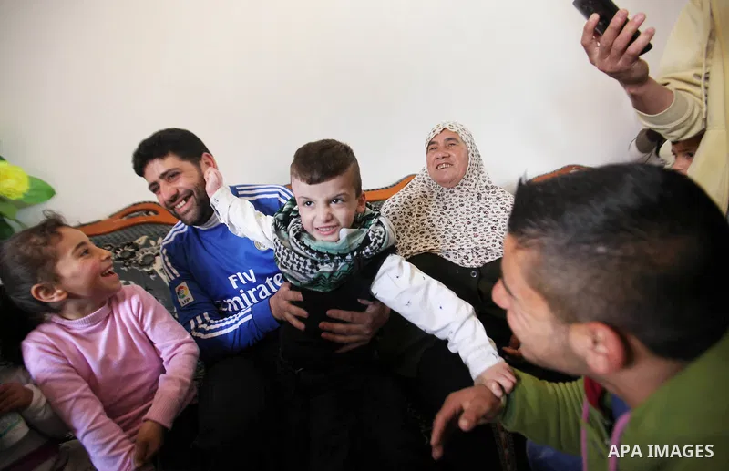 Palestinian boy Ahmed Dawabsha, 5, who suffered severe burns in an arson attack by suspected Jewish attackers on his family home last July and in which his younger brother, Ali, and his parents both died, is welcomed by...