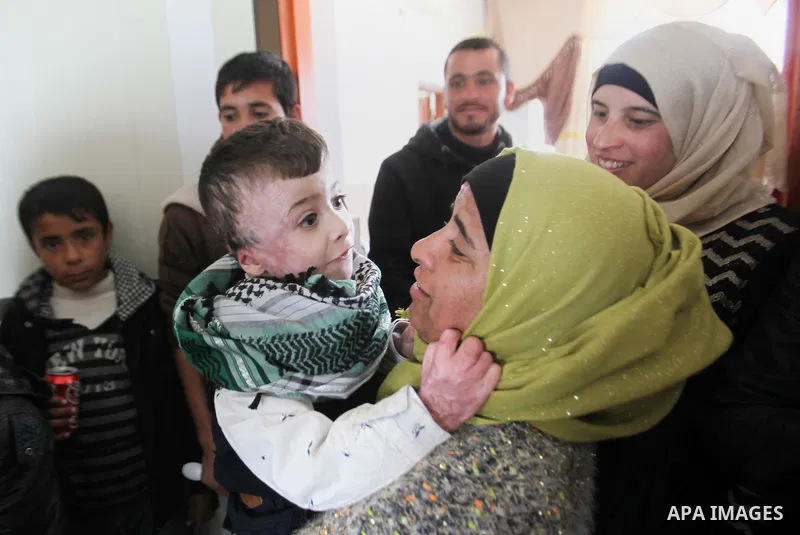 Palestinian boy Ahmed Dawabsha, 5, who suffered severe burns in an arson attack by suspected Jewish attackers on his family home last July and in which his younger brother, Ali, and his parents both died, is welcomed by...