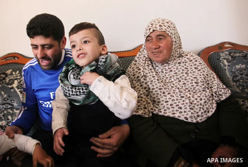 Palestinian boy Ahmed Dawabsha, 5, who suffered severe burns in an arson attack by suspected Jewish attackers on his family home last July and in which his younger brother, Ali, and his parents both died, is welcomed by...