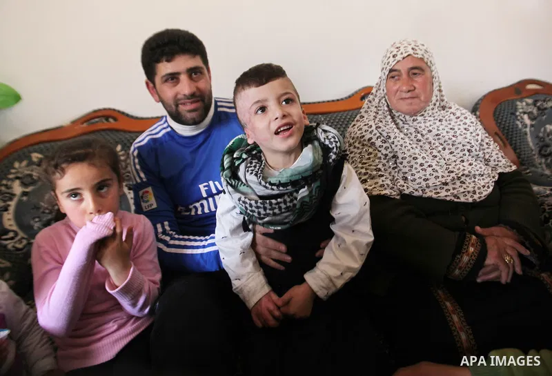 Palestinian boy Ahmed Dawabsha, 5, who suffered severe burns in an arson attack by suspected Jewish attackers on his family home last July and in which his younger brother, Ali, and his parents both died, is welcomed by...
