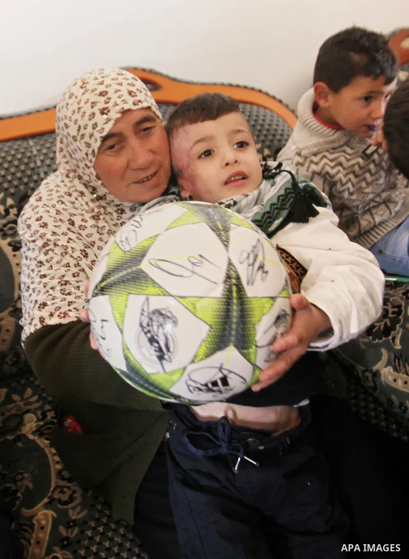 Palestinian boy Ahmed Dawabsha, 5, who suffered severe burns in an arson attack by suspected Jewish attackers on his family home last July and in which his younger brother, Ali, and his parents both died, is welcomed by...