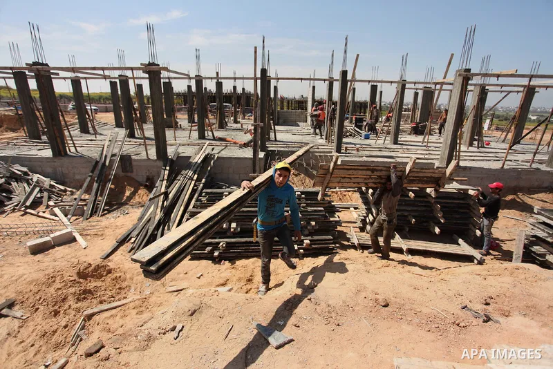 Palestinian construction labourers work on a Turkish funded project to build 320 housing units for families who lost their homes during the 50-day war between Israel and Hamas-led militants in the summer of 2014, east of...