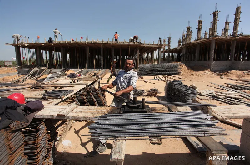 Palestinian construction labourers work on a Turkish funded project to build 320 housing units for families who lost their homes during the 50-day war between Israel and Hamas-led militants in the summer of 2014, east of...