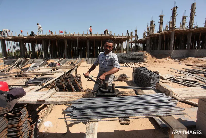 Palestinian construction labourers work on a Turkish funded project to build 320 housing units for families who lost their homes during the 50-day war between Israel and Hamas-led militants in the summer of 2014, east of...