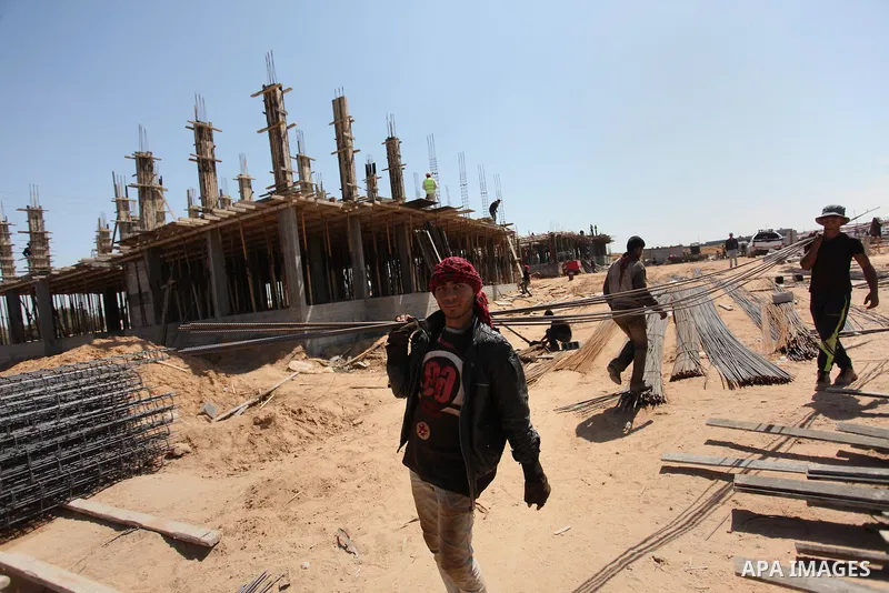 Palestinian construction labourers work on a Turkish funded project to build 320 housing units for families who lost their homes during the 50-day war between Israel and Hamas-led militants in the summer of 2014, east of...