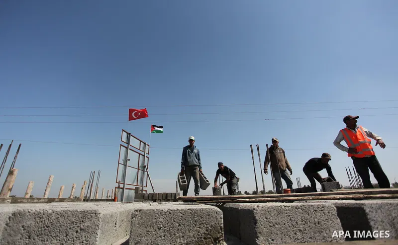 Palestinian construction labourers work on a Turkish funded project to build 320 housing units for families who lost their homes during the 50-day war between Israel and Hamas-led militants in the summer of 2014, east of...