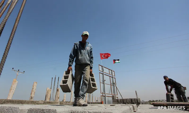 Palestinian construction labourers work on a Turkish funded project to build 320 housing units for families who lost their homes during the 50-day war between Israel and Hamas-led militants in the summer of 2014, east of...