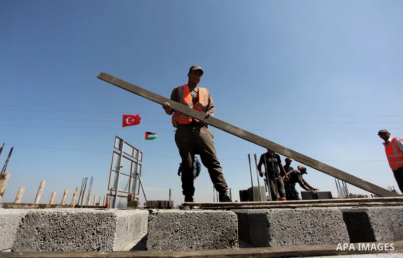 Palestinian construction labourers work on a Turkish funded project to build 320 housing units for families who lost their homes during the 50-day war between Israel and Hamas-led militants in the summer of 2014, east of...
