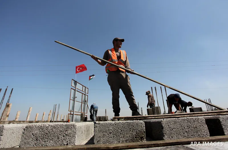 Palestinian construction labourers work on a Turkish funded project to build 320 housing units for families who lost their homes during the 50-day war between Israel and Hamas-led militants in the summer of 2014, east of...