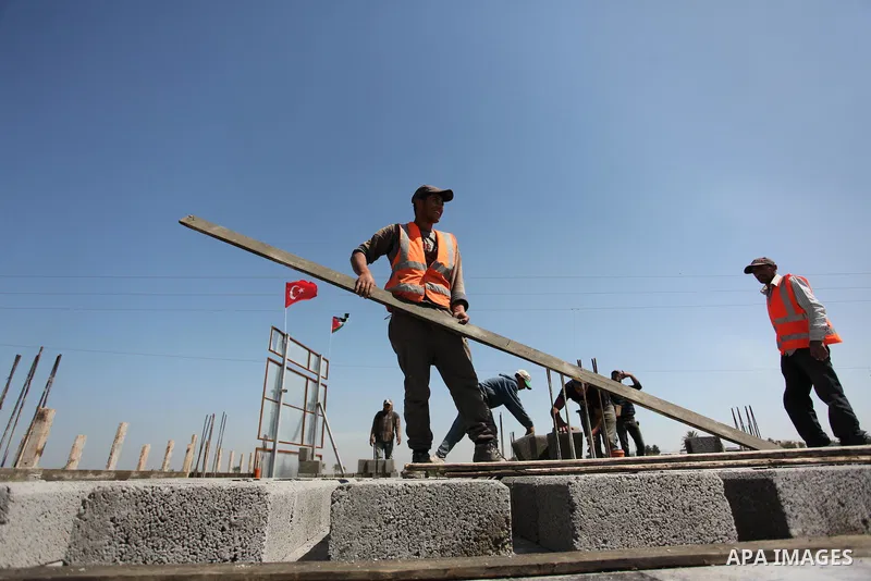 Palestinian construction labourers work on a Turkish funded project to build 320 housing units for families who lost their homes during the 50-day war between Israel and Hamas-led militants in the summer of 2014, east of...
