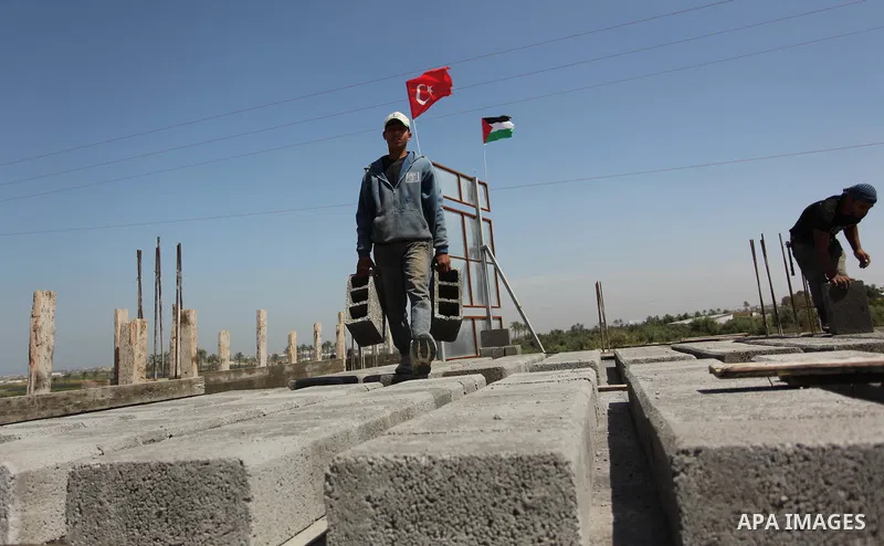 Palestinian construction labourers work on a Turkish funded project to build 320 housing units for families who lost their homes during the 50-day war between Israel and Hamas-led militants in the summer of 2014, east of...