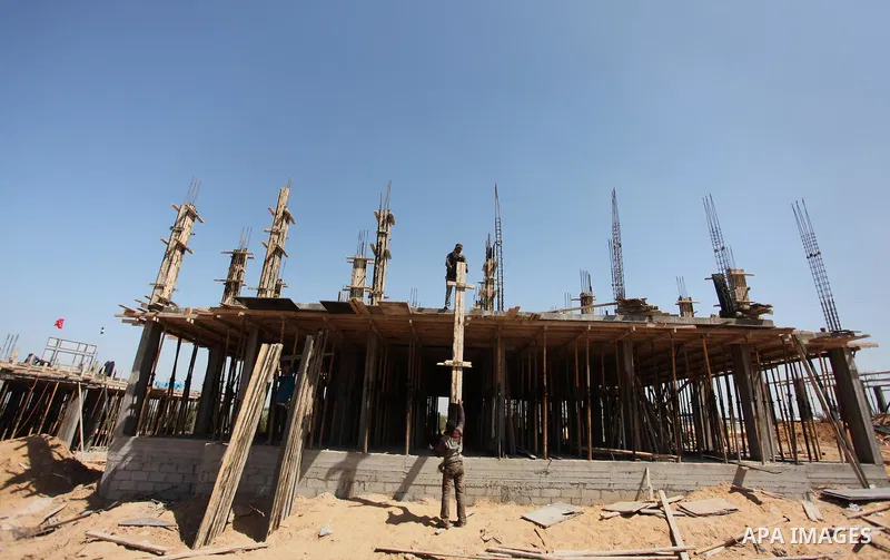 Palestinian construction labourers work on a Turkish funded project to build 320 housing units for families who lost their homes during the 50-day war between Israel and Hamas-led militants in the summer of 2014, east of...