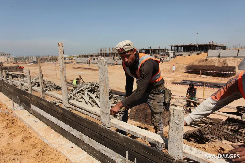 Palestinian construction labourers work on a Turkish funded project to build 320 housing units for families who lost their homes during the 50-day war between Israel and Hamas-led militants in the summer of 2014, east of...