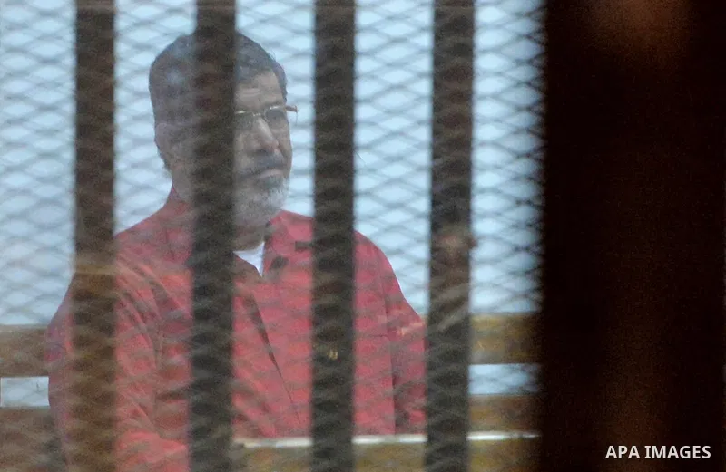 Ousted Egyptian president Mohammed Morsi sits behind bars during his trail as part of the so-called 'Qatar espionage' case, in a court in Cairo on March 23, 2016. The defendants are accused of 'leaking important national...