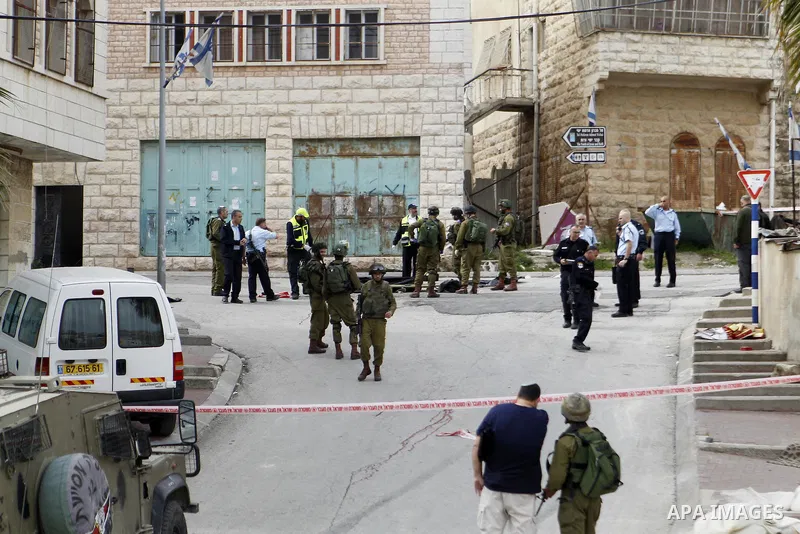 Israeli security forces carry the body of a Palestinian man tried to stab an Israeli soldier before being shot dead, in the Israeli occupied West Bank city of Hebron, on March 24, 2016. Two Palestinians were killed by Is...