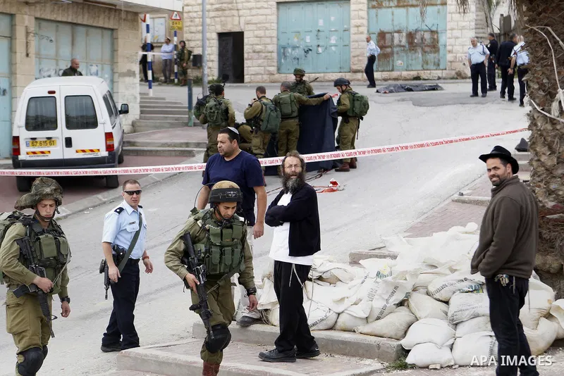 Israeli security forces carry the body of a Palestinian man tried to stab an Israeli soldier before being shot dead, in the Israeli occupied West Bank city of Hebron, on March 24, 2016. Two Palestinians were killed by Is...