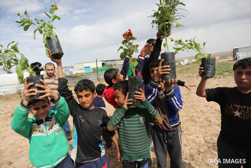 Palestinian children are grown roses during a rally demanding to reconstruction of their homes which destroyed during 2014 war in Shejaiya neighborhood in Gaza city, on March 24, 2016. Photo by Ashraf Amra