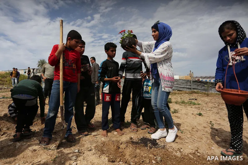 Palestinian children are grown roses during a rally demanding to reconstruction of their homes which destroyed during 2014 war in Shejaiya neighborhood in Gaza city, on March 24, 2016. Photo by Ashraf Amra