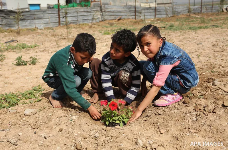 Palestinian children are grown roses during a rally demanding to reconstruction of their homes which destroyed during 2014 war in Shejaiya neighborhood in Gaza city, on March 24, 2016. Photo by Ashraf Amra