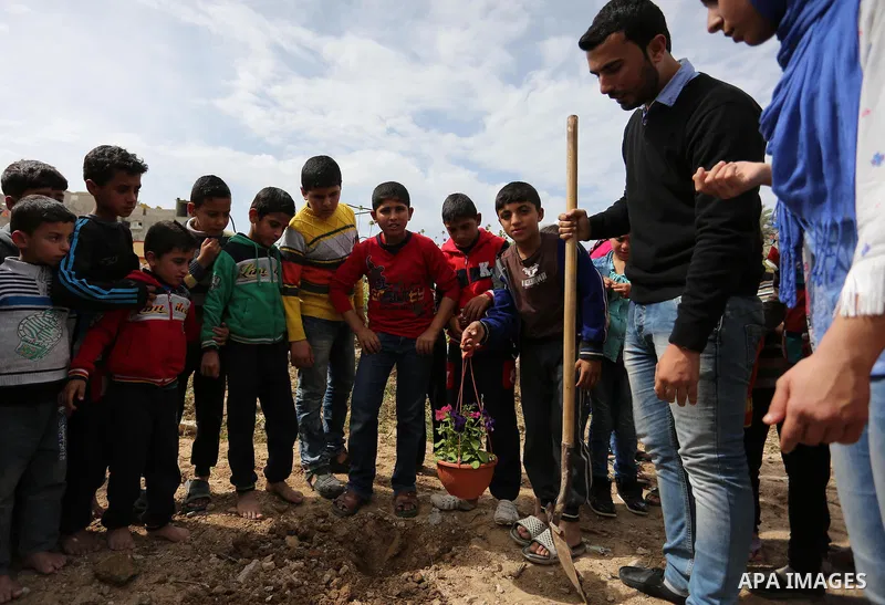 Palestinian children are grown roses during a rally demanding to reconstruction of their homes which destroyed during 2014 war in Shejaiya neighborhood in Gaza city, on March 24, 2016. Photo by Ashraf Amra