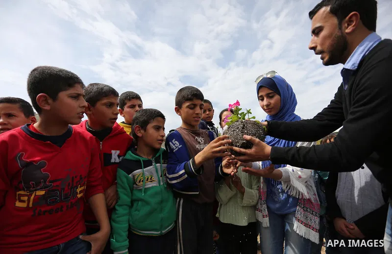 Palestinian children are grown roses during a rally demanding to reconstruction of their homes which destroyed during 2014 war in Shejaiya neighborhood in Gaza city, on March 24, 2016. Photo by Ashraf Amra
