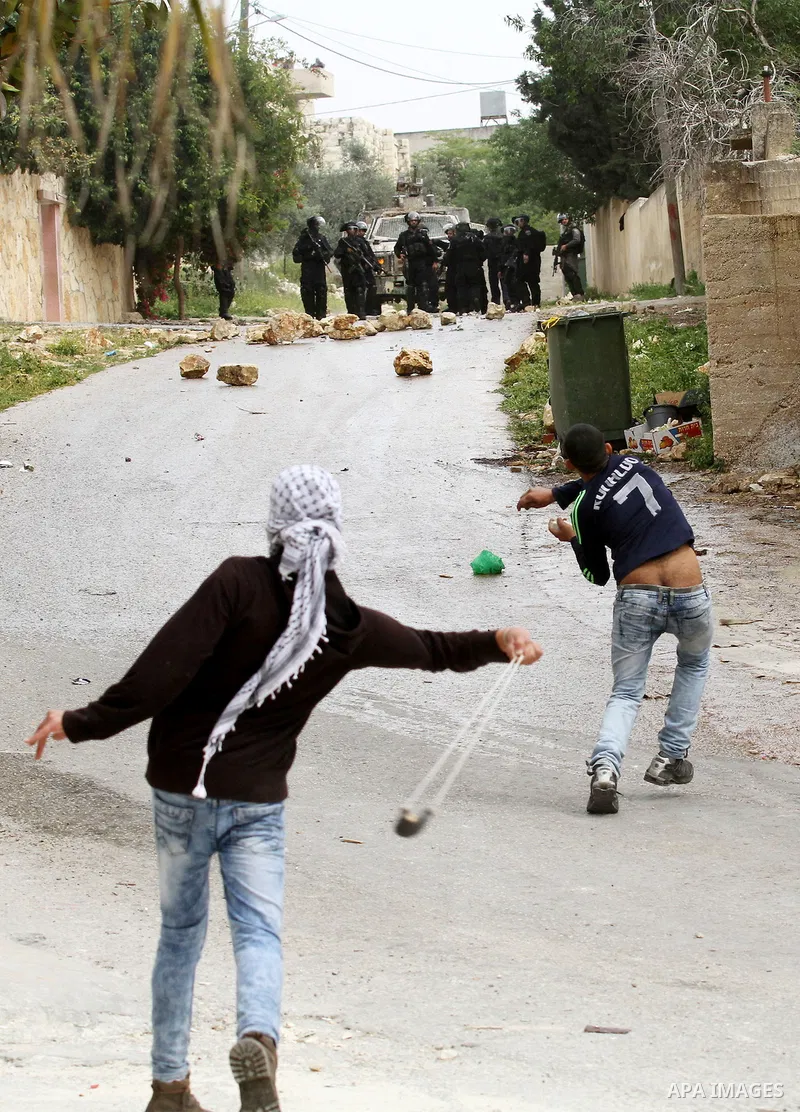Palestinian protesters hurl stones toward Israeli security forces during clashes following a demonstration against the expropriation of Palestinian land by Israel in the village of Kfar Qaddum, near Nablus, in the occupi...