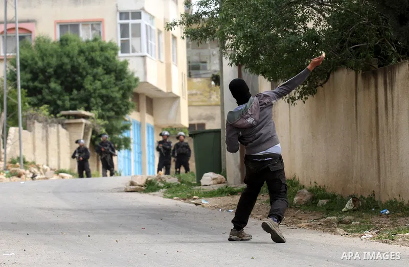 A Palestinian protester hurlsl stones toward Israeli security forces during clashes following a demonstration against the expropriation of Palestinian land by Israel in the village of Kfar Qaddum, near Nablus, in the occ...