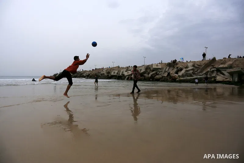 Palestinian children play volleyball at the beach of the Mediterranean sea on the coast of Gaza city, on March 25, 2016. Photo by Yasser Qudih