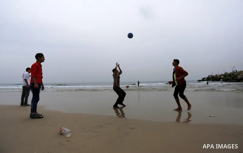 Palestinian children play volleyball at the beach of the Mediterranean sea on the coast of Gaza city, on March 25, 2016. Photo by Yasser Qudih