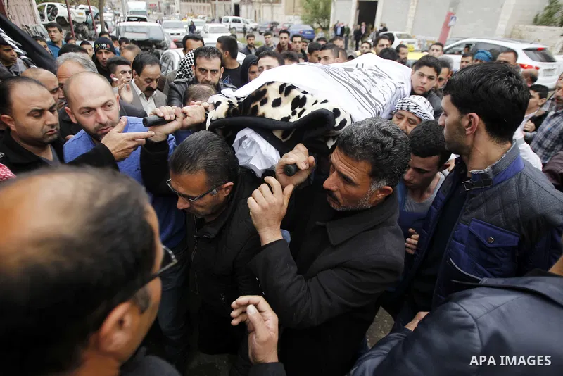 Relatives mourn next the body of Ramzi al-Qasrawi, 21, a Palestinian man who was killed in a reported stabbing attack, during his funeral in the West Bank town of Hebron on March 26, 2016. Ramzi al-Qasrawi was killed on...