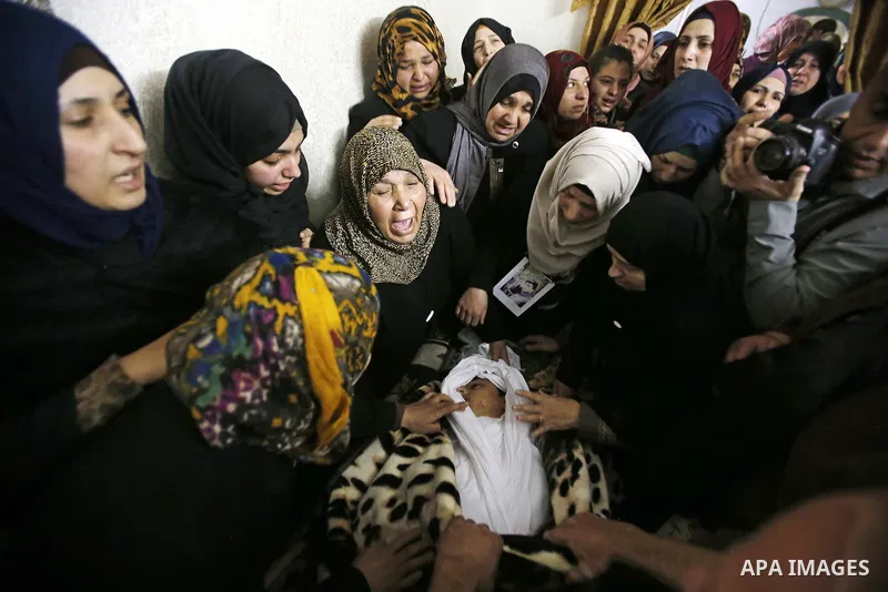 Relatives mourn next the body of Ramzi al-Qasrawi, 21, a Palestinian man who was killed in a reported stabbing attack, during his funeral in the West Bank town of Hebron on March 26, 2016. Ramzi al-Qasrawi was killed on...