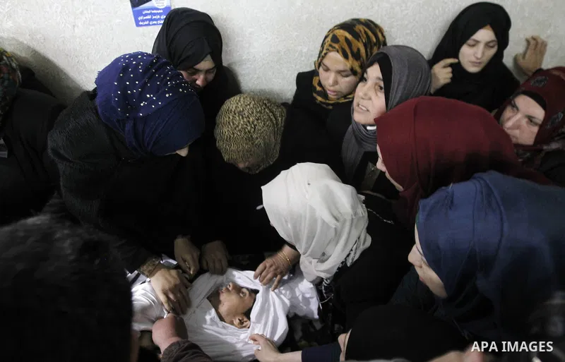 Relatives mourn next the body of Ramzi al-Qasrawi, 21, a Palestinian man who was killed in a reported stabbing attack, during his funeral in the West Bank town of Hebron on March 26, 2016. Ramzi al-Qasrawi was killed on...