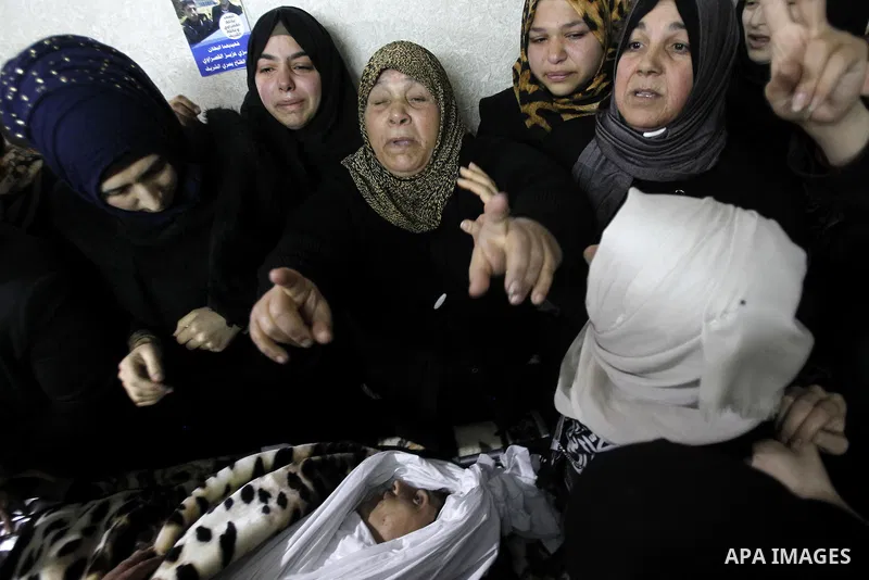 Relatives mourn next the body of Ramzi al-Qasrawi, 21, a Palestinian man who was killed in a reported stabbing attack, during his funeral in the West Bank town of Hebron on March 26, 2016. Ramzi al-Qasrawi was killed on...