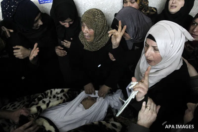 Relatives mourn next the body of Ramzi al-Qasrawi, 21, a Palestinian man who was killed in a reported stabbing attack, during his funeral in the West Bank town of Hebron on March 26, 2016. Ramzi al-Qasrawi was killed on...