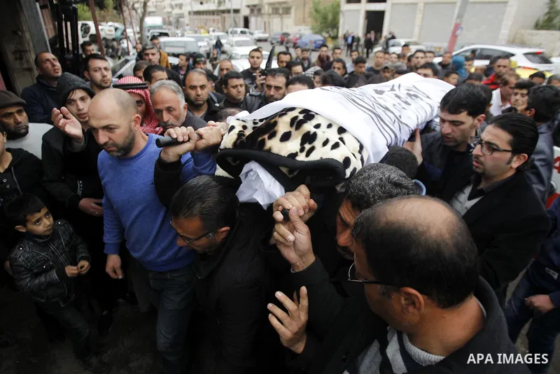 Relatives mourn next the body of Ramzi al-Qasrawi, 21, a Palestinian man who was killed in a reported stabbing attack, during his funeral in the West Bank town of Hebron on March 26, 2016. Ramzi al-Qasrawi was killed on...