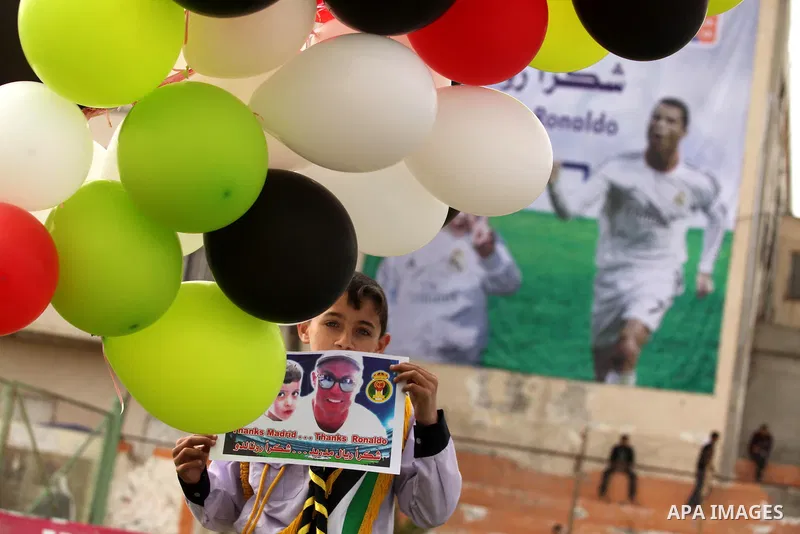 Palestinian chlidren hold ballons and posters bearing a portrait of Palestinian boy Ahmed Dawabsha, 5, who suffered severe burns in an arson attack by suspected Jewish attackers on his family home last July and in which...