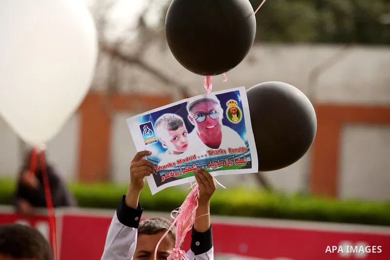 Palestinian chlidren hold ballons and posters bearing a portrait of Palestinian boy Ahmed Dawabsha, 5, who suffered severe burns in an arson attack by suspected Jewish attackers on his family home last July and in which...