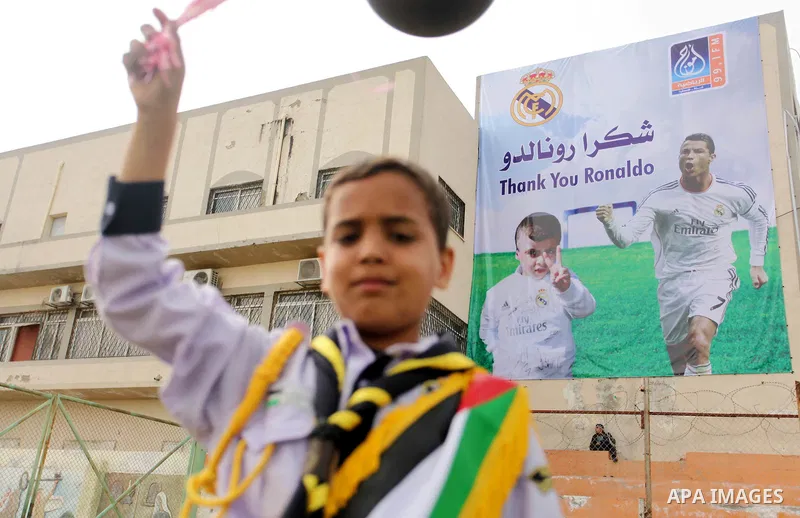 Palestinian chlidren hold ballons and posters bearing a portrait of Palestinian boy Ahmed Dawabsha, 5, who suffered severe burns in an arson attack by suspected Jewish attackers on his family home last July and in which...