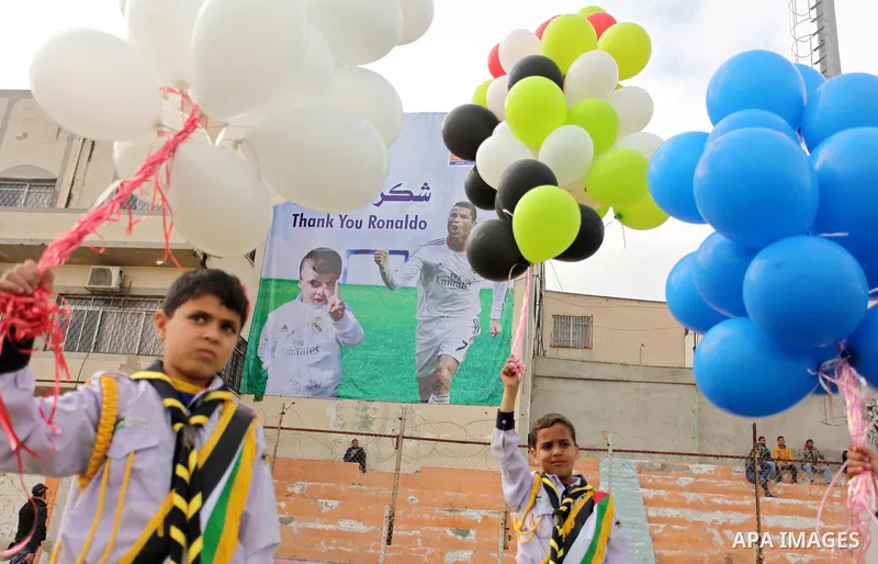 Palestinian chlidren hold ballons and posters bearing a portrait of Palestinian boy Ahmed Dawabsha, 5, who suffered severe burns in an arson attack by suspected Jewish attackers on his family home last July and in which...