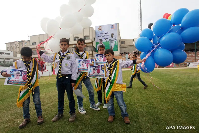 Palestinian chlidren hold ballons and posters bearing a portrait of Palestinian boy Ahmed Dawabsha, 5, who suffered severe burns in an arson attack by suspected Jewish attackers on his family home last July and in which...