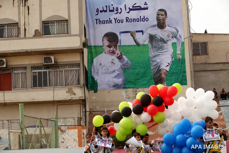 Palestinian chlidren hold ballons and posters bearing a portrait of Palestinian boy Ahmed Dawabsha, 5, who suffered severe burns in an arson attack by suspected Jewish attackers on his family home last July and in which...
