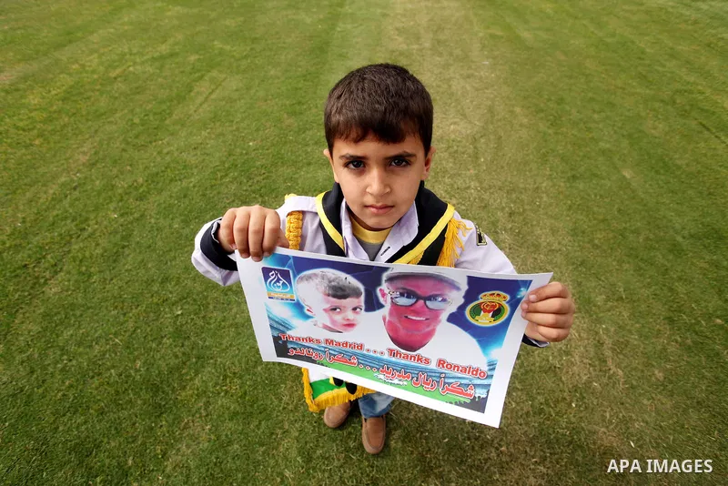 Palestinian chlidren hold ballons and posters bearing a portrait of Palestinian boy Ahmed Dawabsha, 5, who suffered severe burns in an arson attack by suspected Jewish attackers on his family home last July and in which...