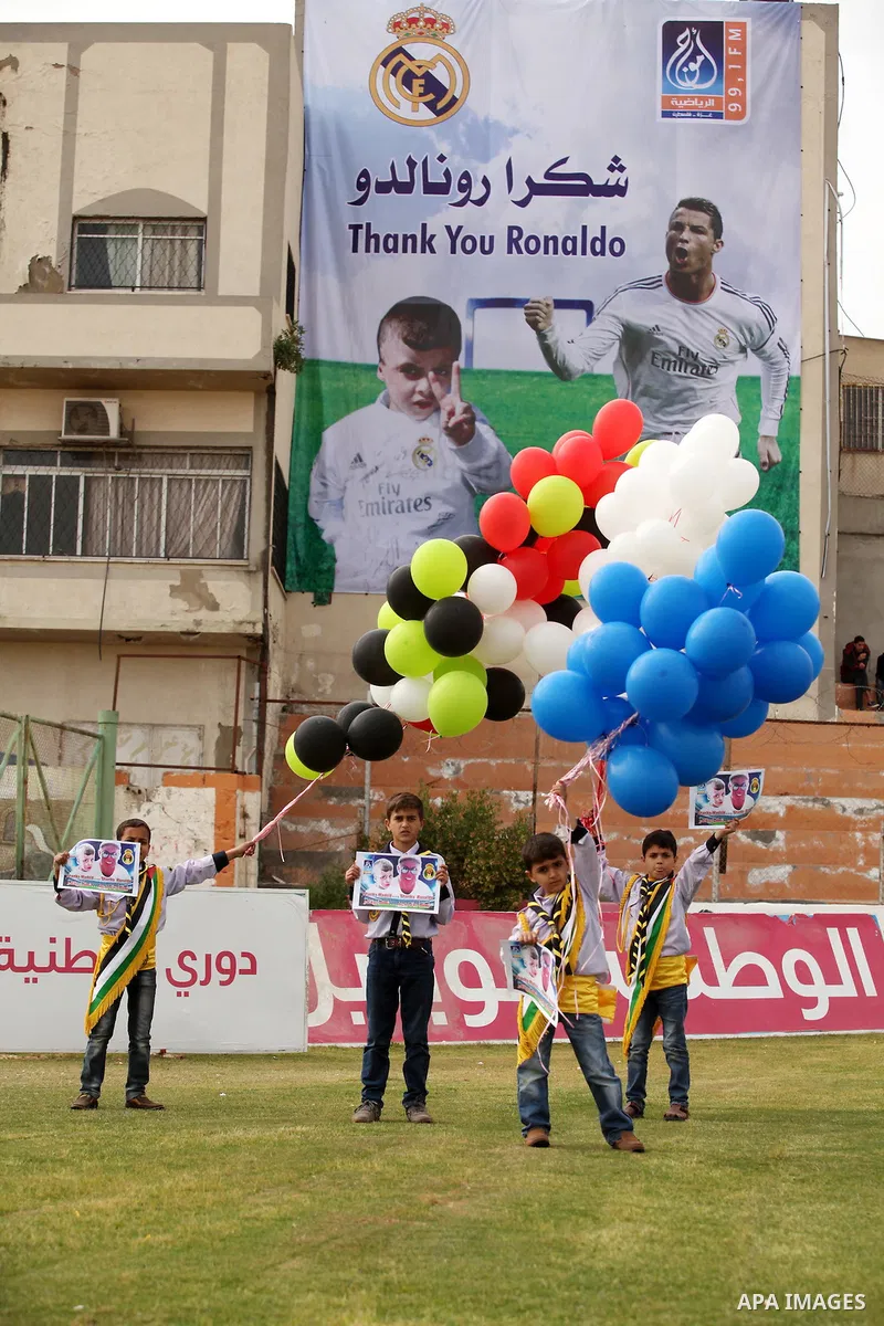 Palestinian chlidren hold ballons and posters bearing a portrait of Palestinian boy Ahmed Dawabsha, 5, who suffered severe burns in an arson attack by suspected Jewish attackers on his family home last July and in which...