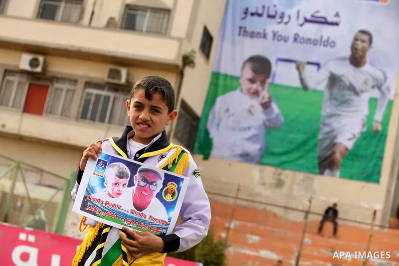 Palestinian chlidren hold ballons and posters bearing a portrait of Palestinian boy Ahmed Dawabsha, 5, who suffered severe burns in an arson attack by suspected Jewish attackers on his family home last July and in which...